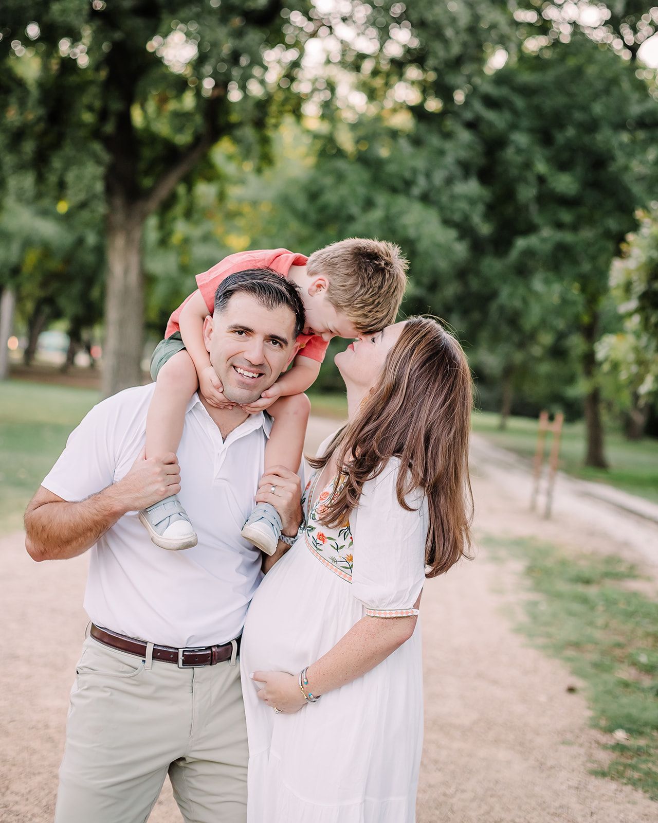 Playful couple photos in white outfits taken in a grassy park setting.