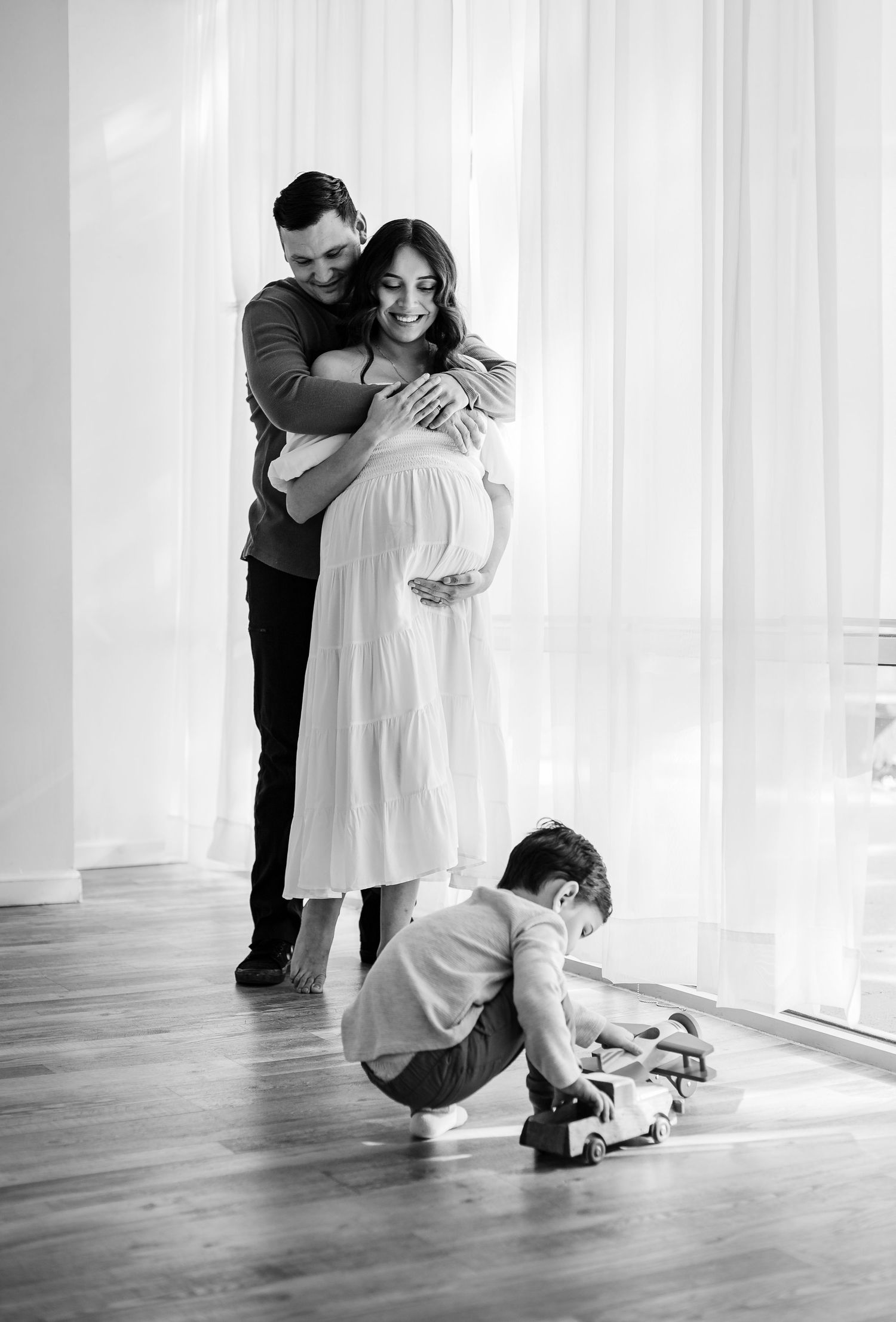 parents looking at child playing with toy