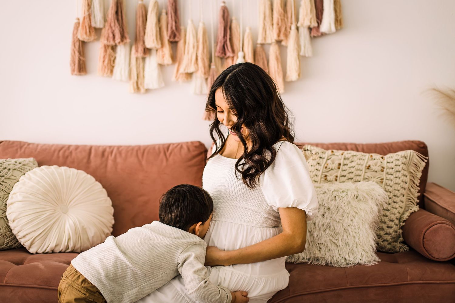child kissing mom on belly maternity photoshoot