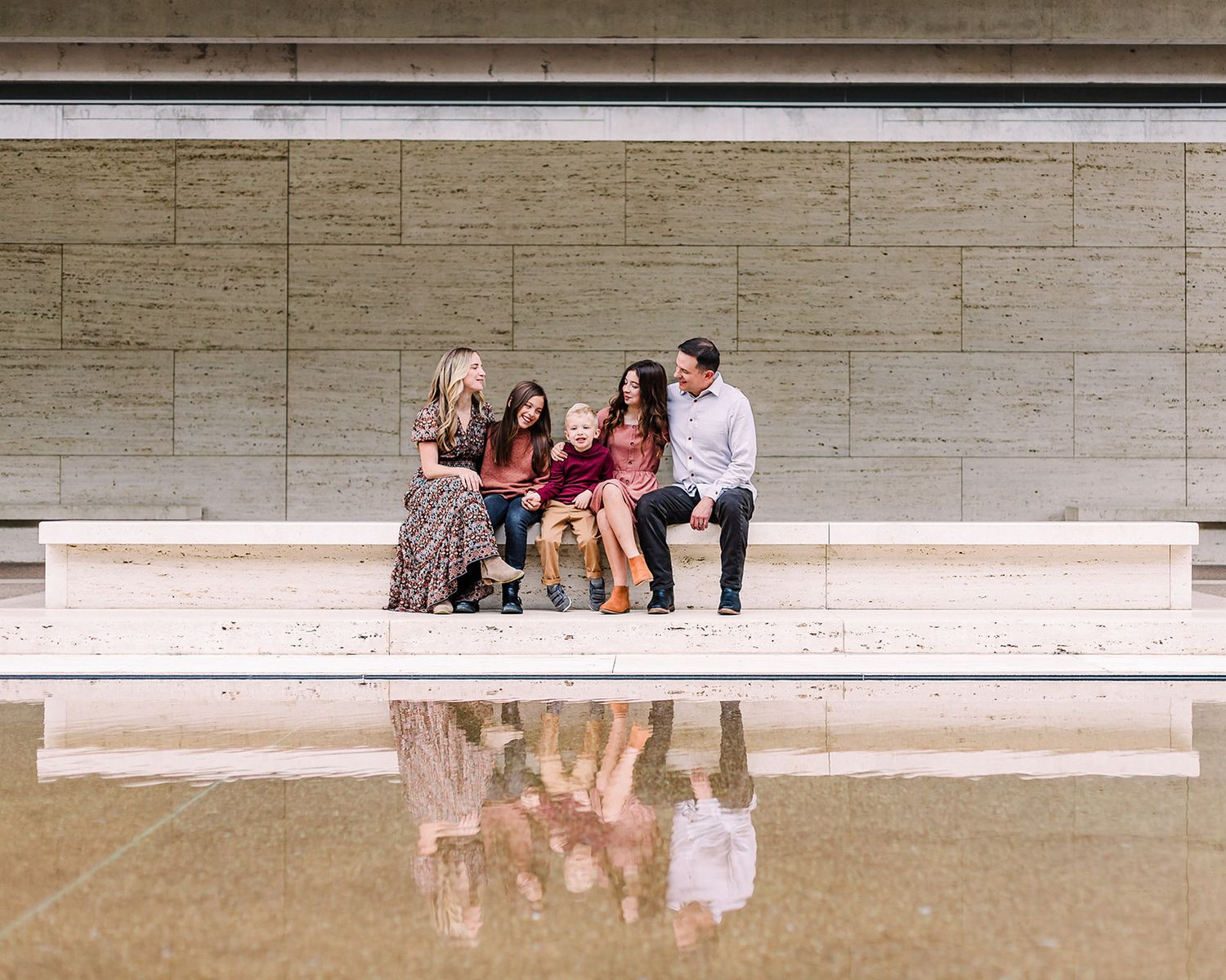 Group photos taken against a modern concrete architectural backdrop.