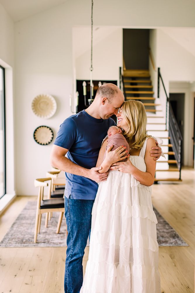 Couple sharing intimate moment in modern minimalist home with white walls and wooden floors.