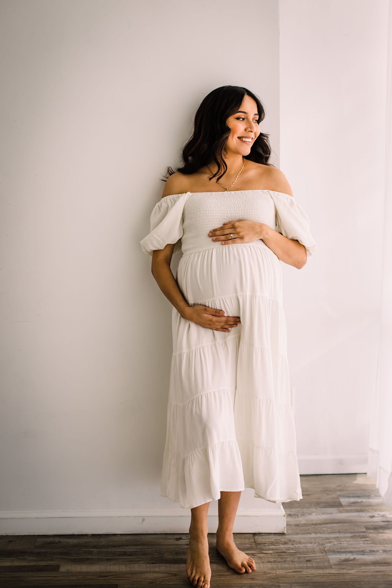 mom in white dress at studio maternity photoshoot