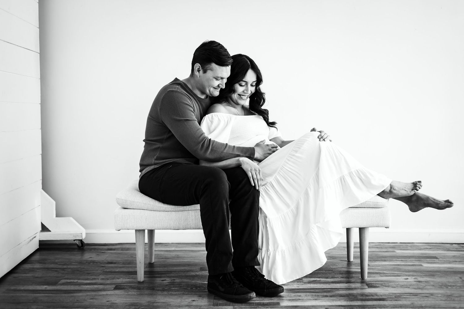 mom and dad looking down at mom pregnant belly studio maternity photos