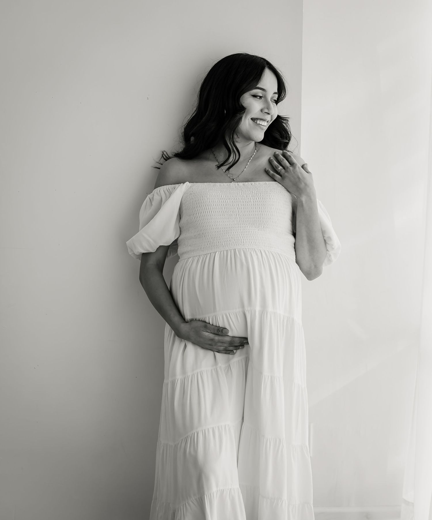 mom in white dress at studio maternity photoshoot