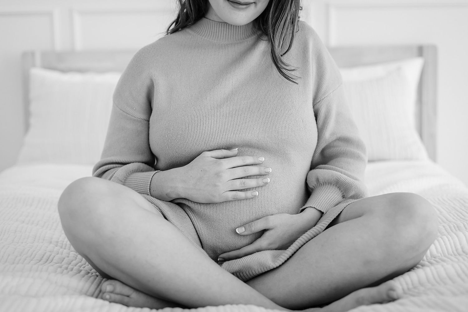 A series of black and white pregnancy photos showing a woman's growing belly at different stages of pregnancy.