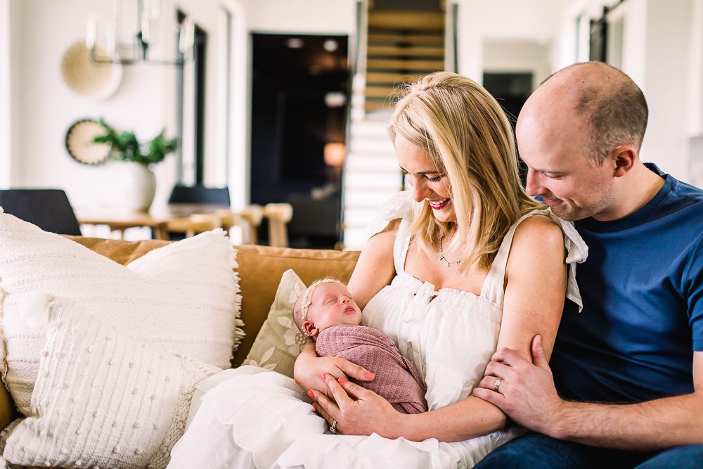 A series of intimate lifestyle family photos showing tender moments between parents and baby in a light-filled home setting.