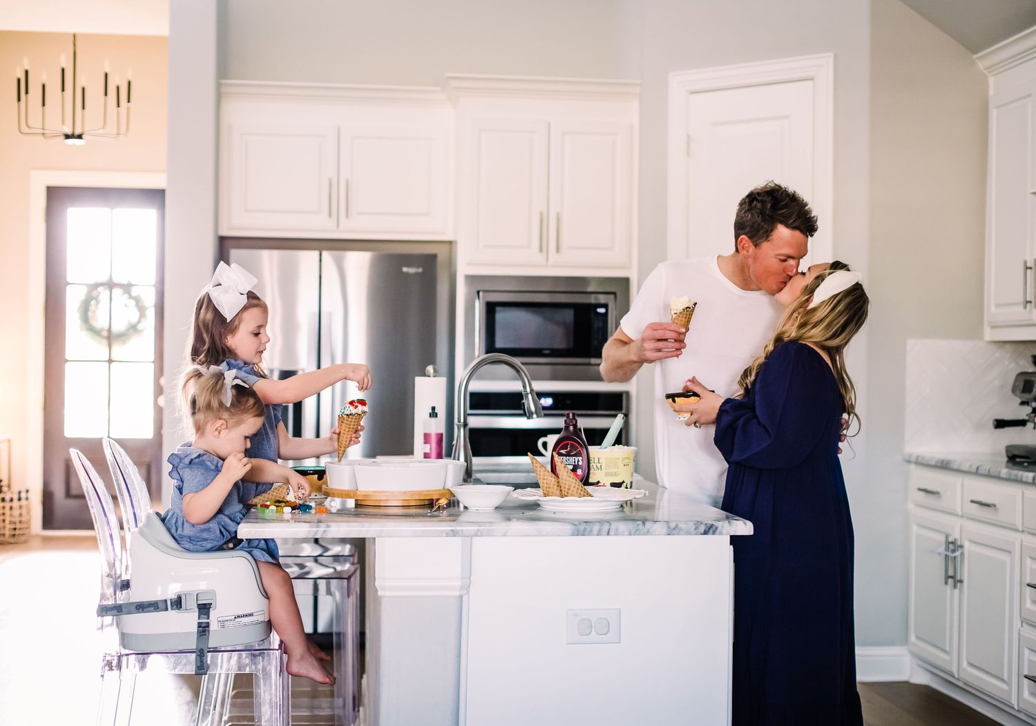 Lifestyle photos of a family spending time together in a modern white kitchen.