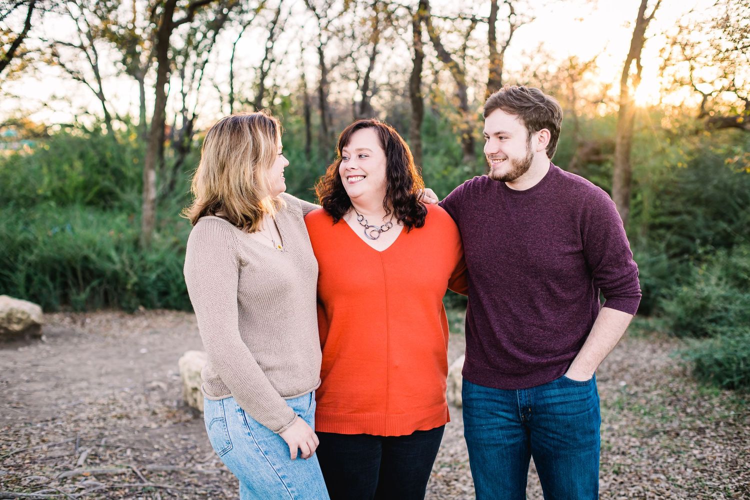 Casual outdoor portrait session in a natural wooded setting during sunset.
