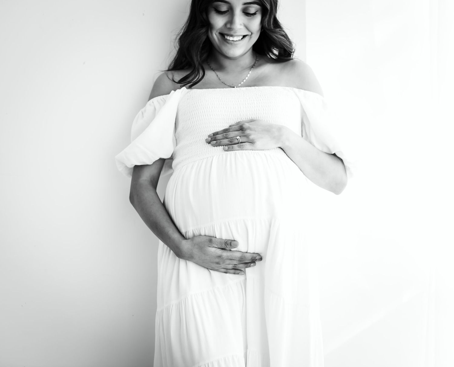 mom in white dress at studio maternity photoshoot