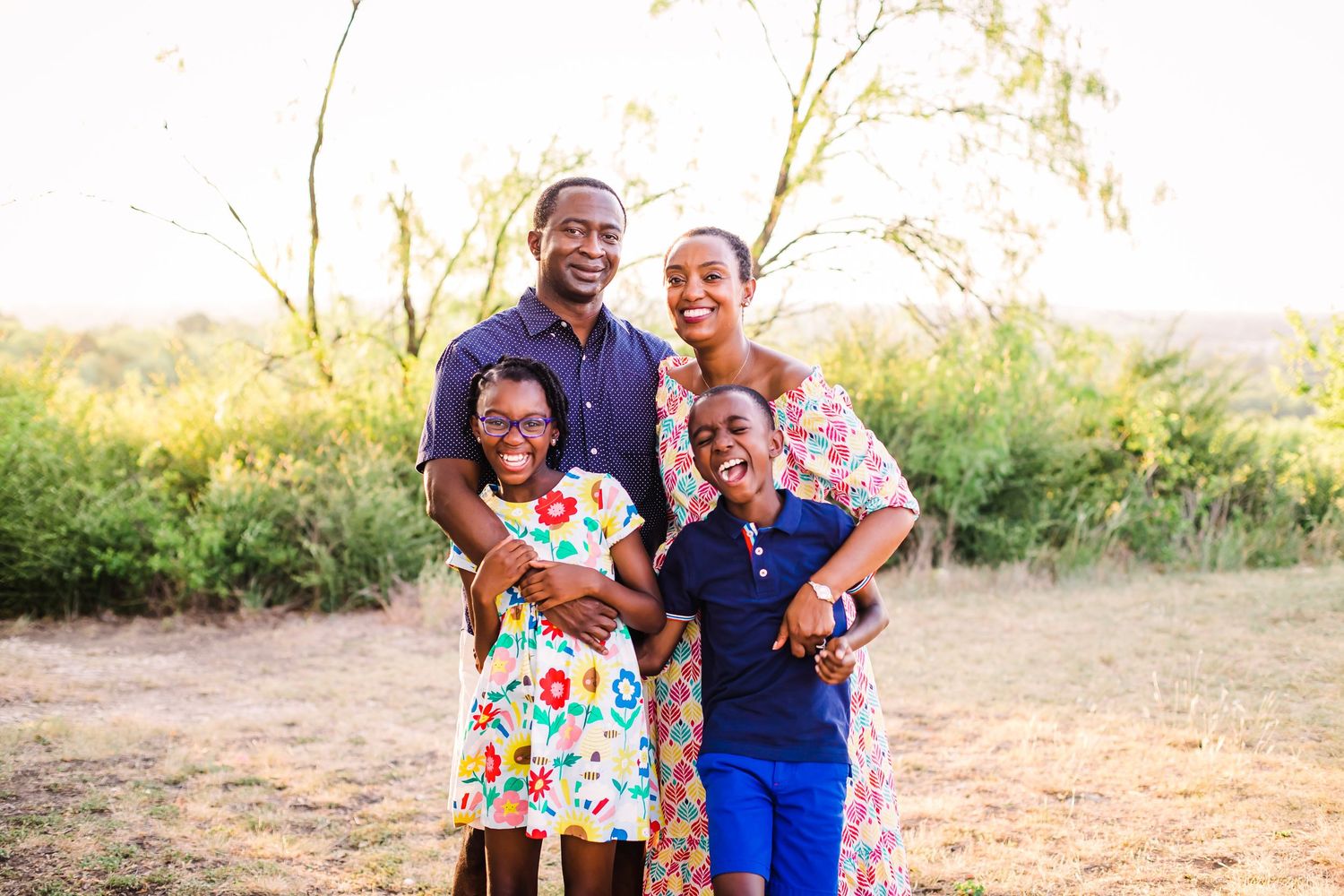 Family enjoying a fun outdoor photoshoot in golden sunlight.