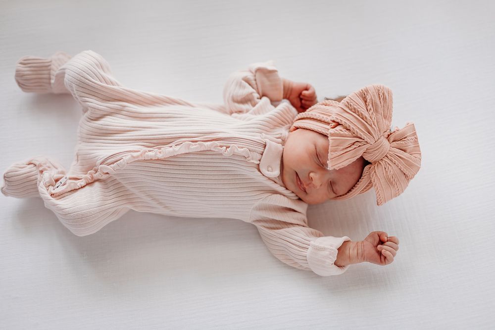 Delicate blush pink pleated fabric swatches arranged in a row showing different folding and draping techniques.