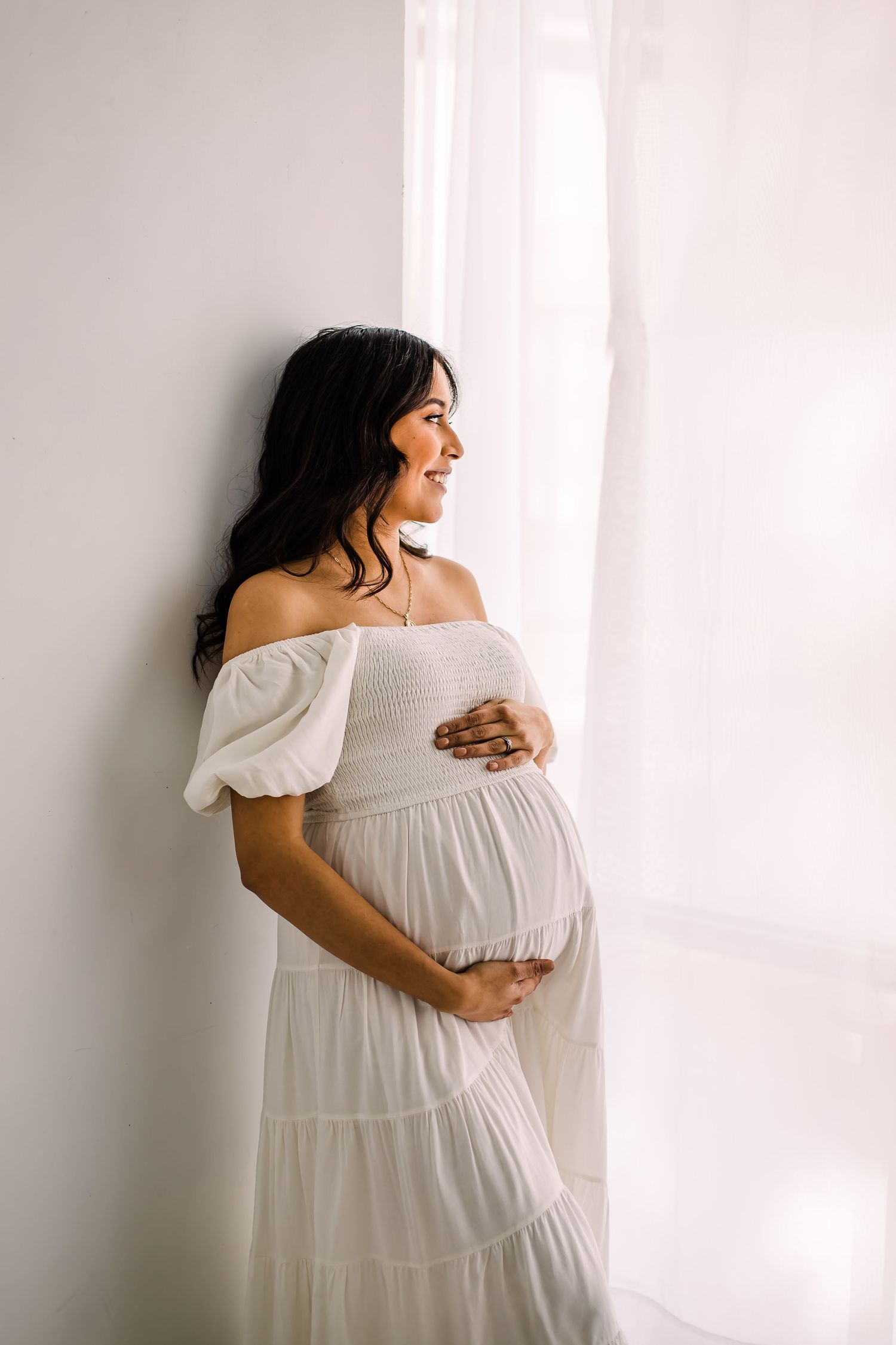 mom in white dress at studio maternity photoshoot