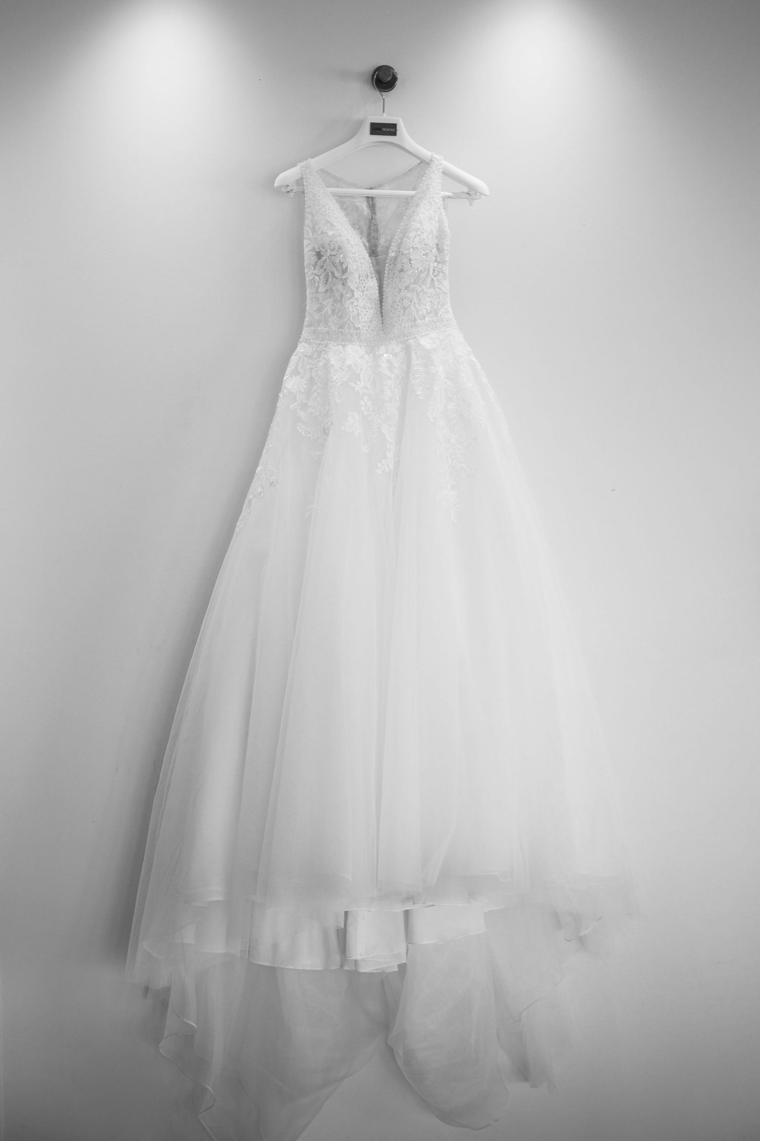 A collection of elegant white wedding dresses hanging on display in soft lighting.
