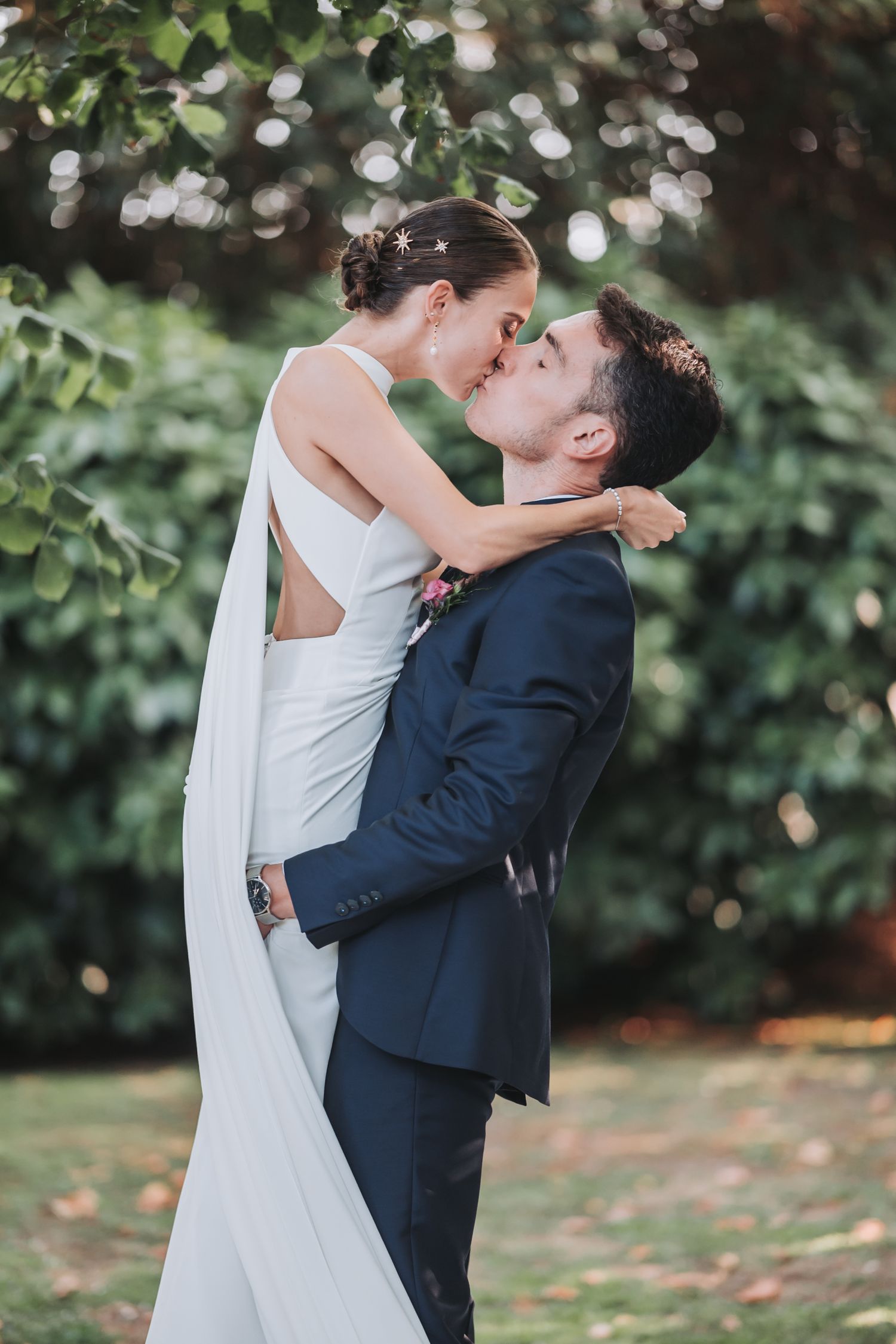 Newlyweds share an intimate embrace during their outdoor garden wedding photoshoot.