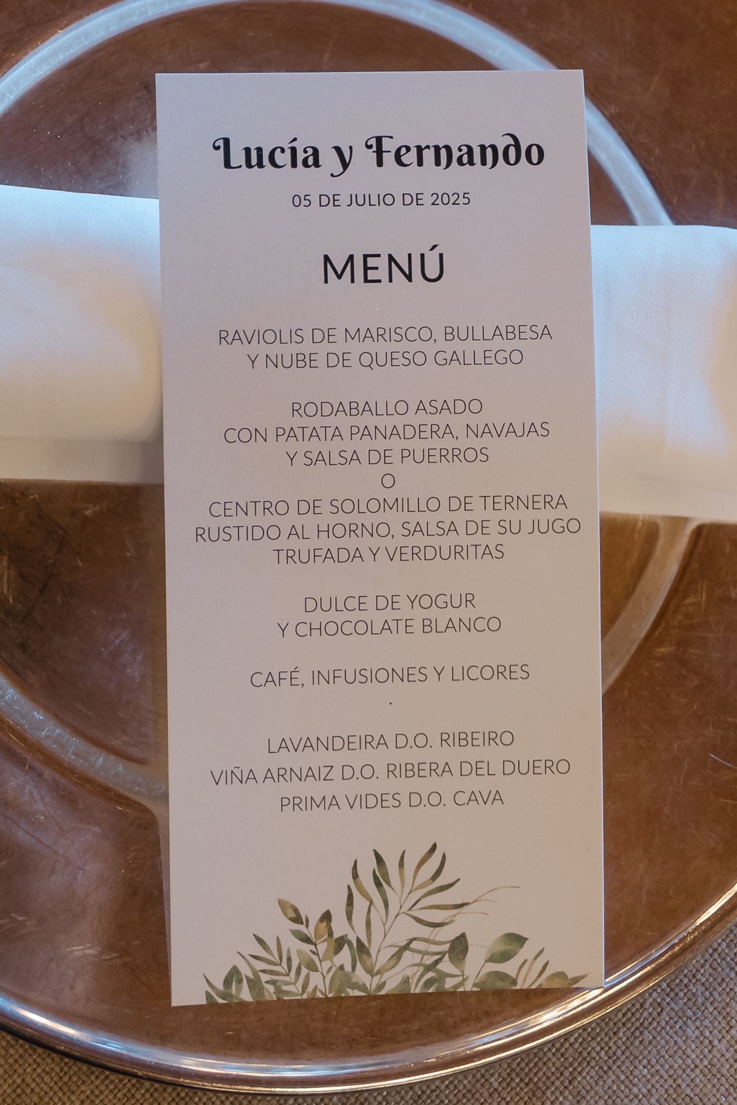 Wedding menu cards with elegant olive branch designs display Spanish food and wine selections at Lucia and Fernando's celebration.