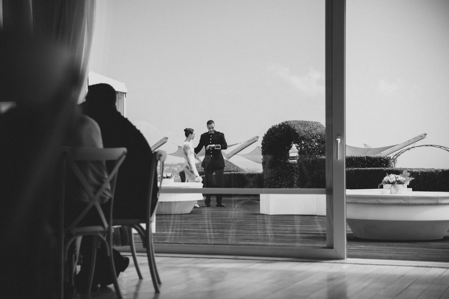 A black and white panoramic sequence of silhouettes against windows showing a dance performance in progress.