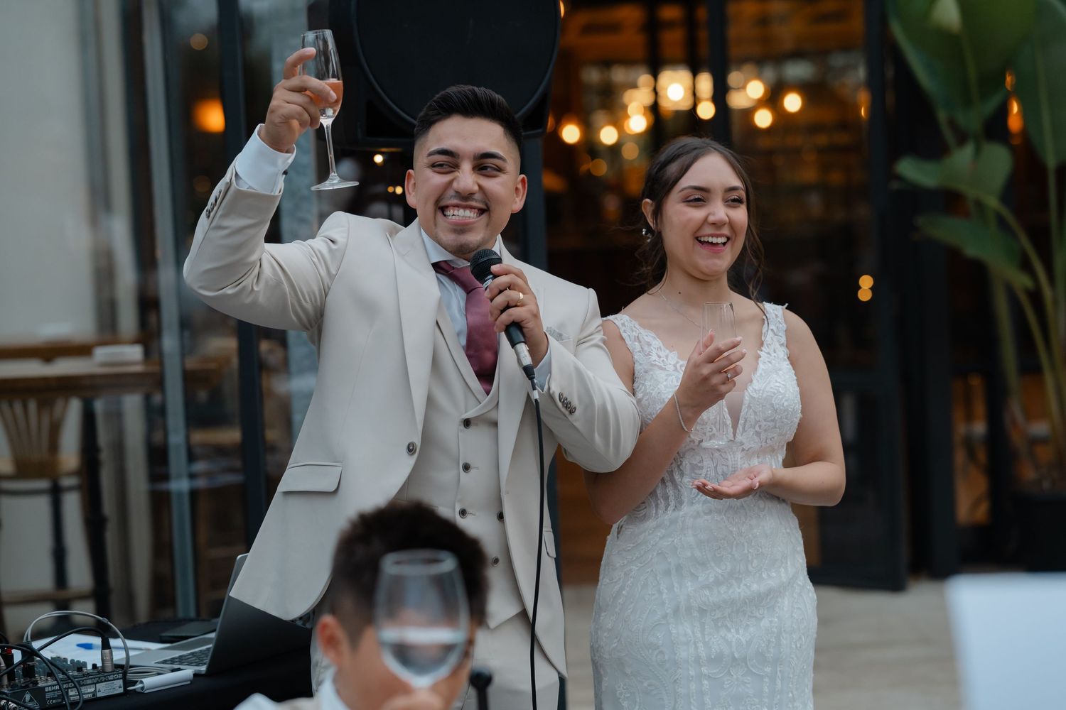 Guests dancing and celebrating at a lively wedding reception with warm ambient lighting.