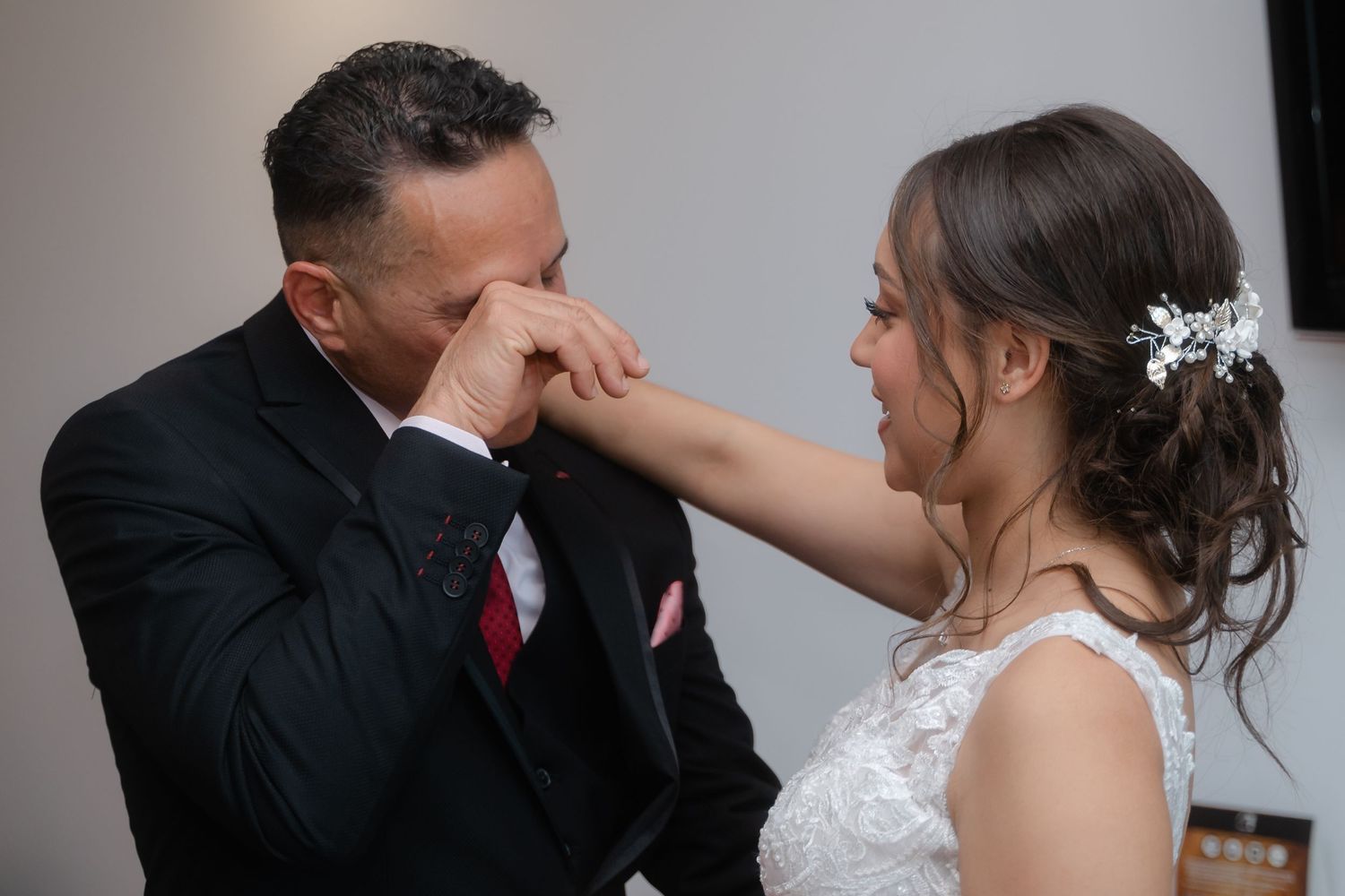 Romantic moment between a couple in wedding attire sharing an intimate gesture.