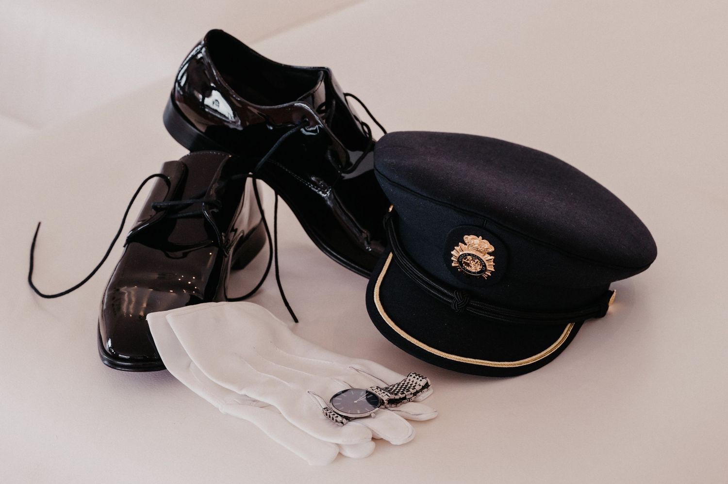 Black leather lace-up boots and dress shoes arranged in a row against a neutral background.