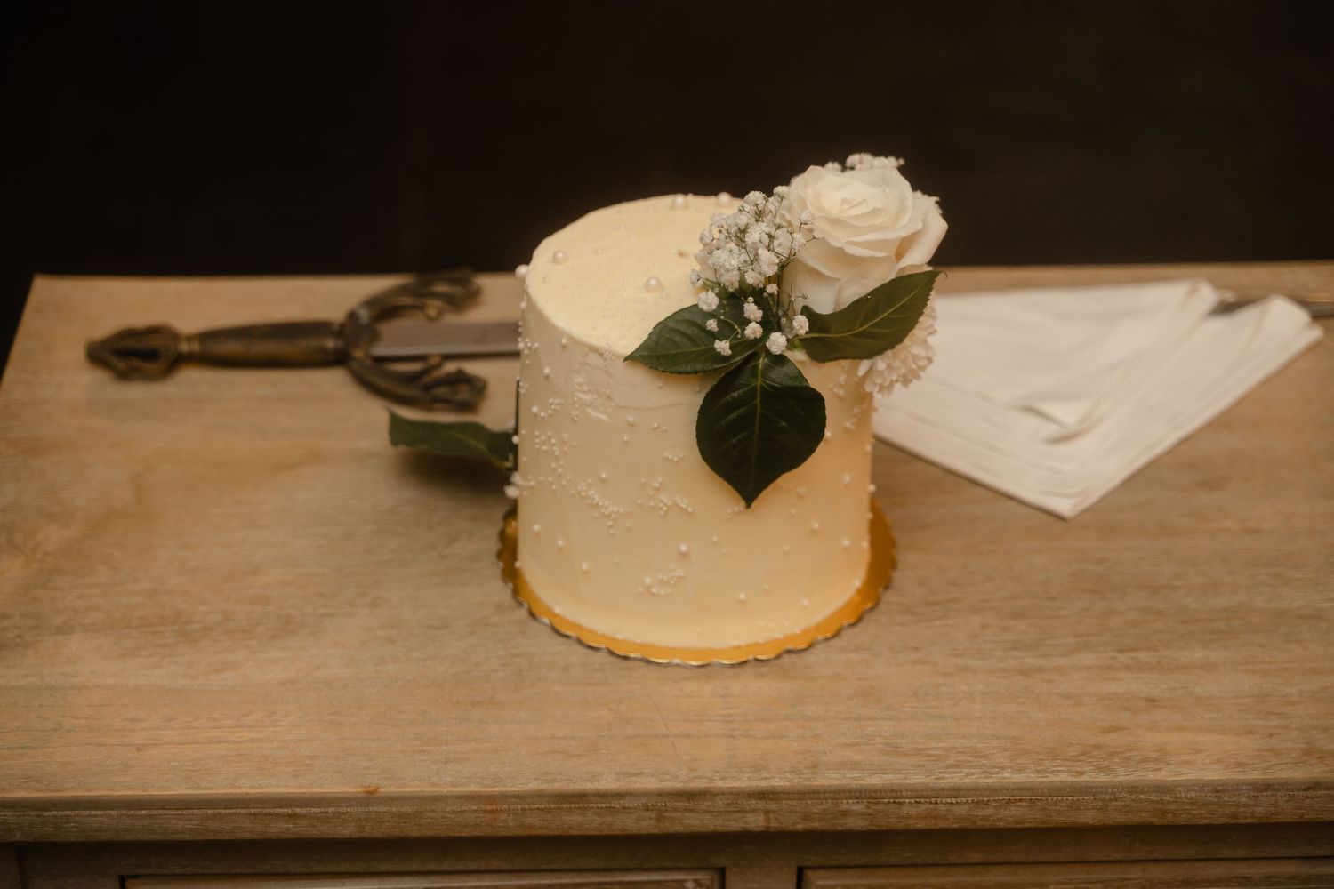 A rustic wooden table setting with plates, greenery, and natural decor elements arranged in an elegant style.