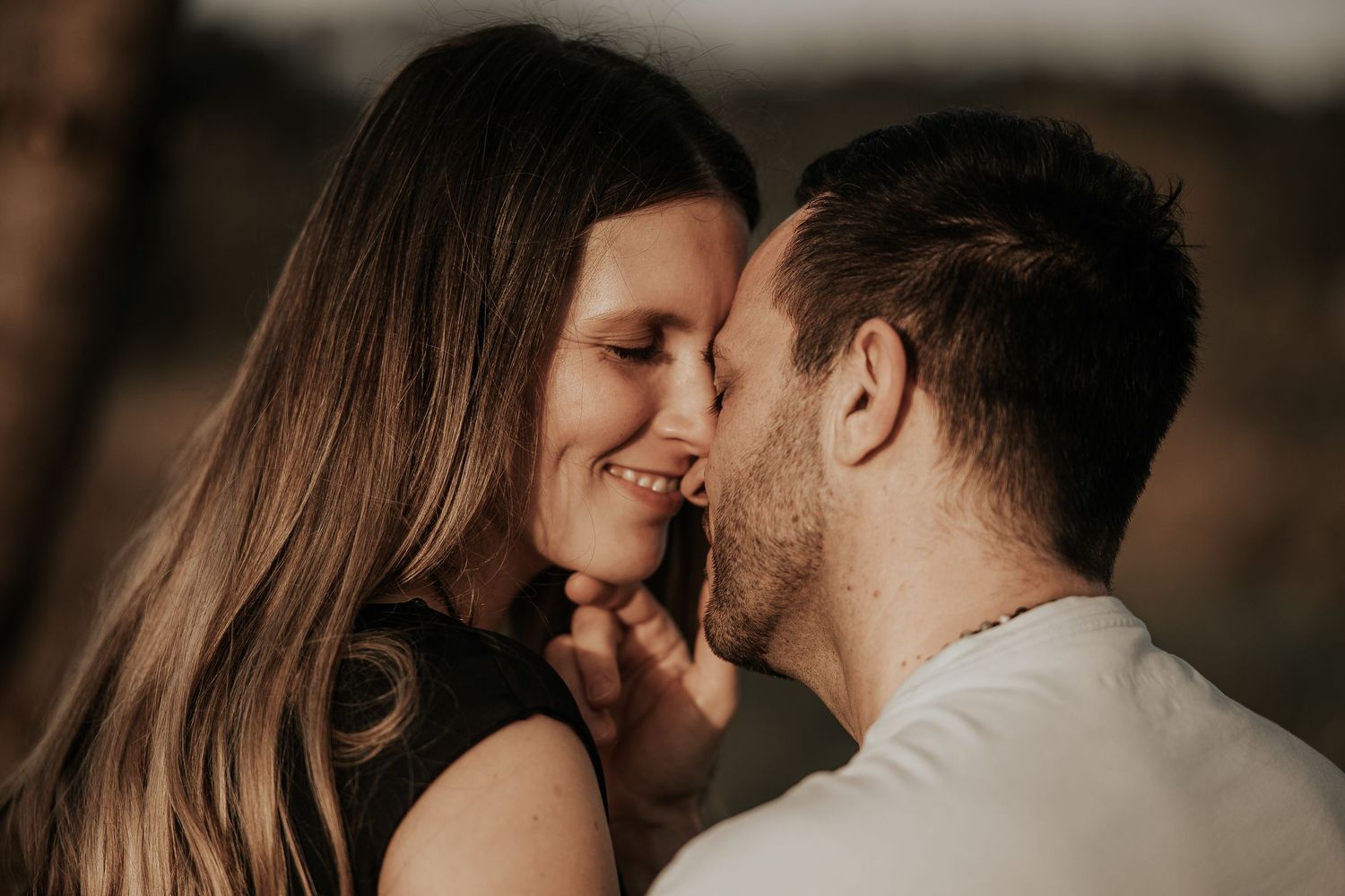 Close-up romantic portraits of couple sharing intimate moments in dramatic lighting.