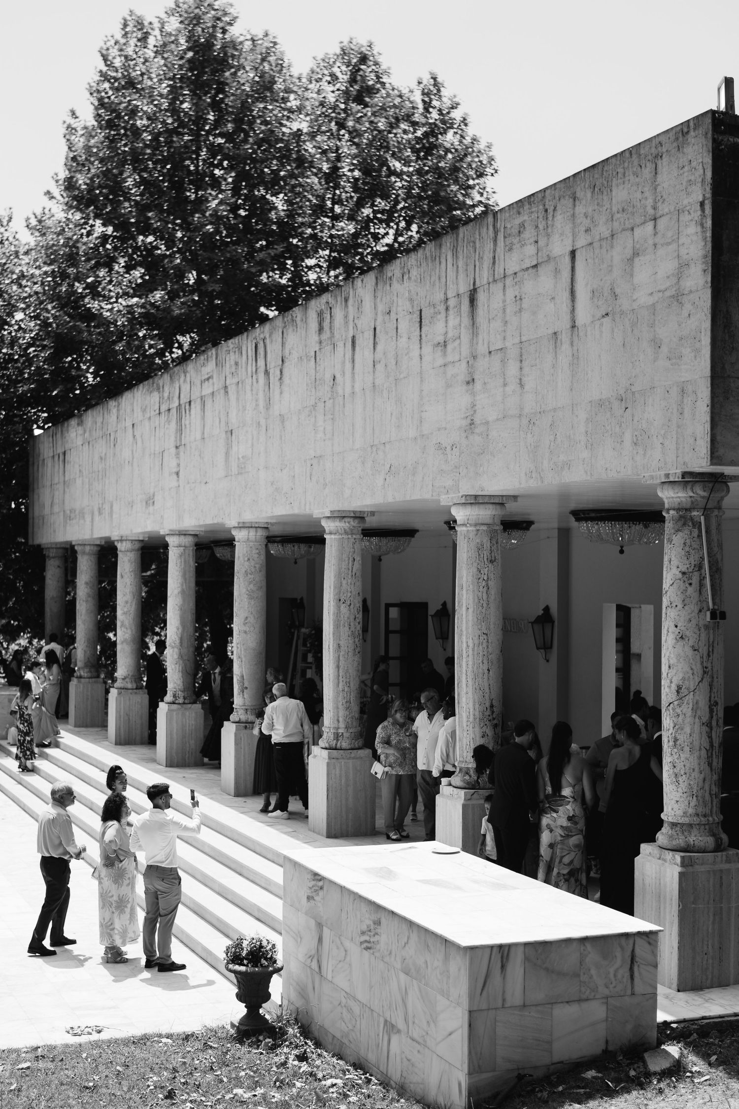 Outdoor colonnade with white pillars and steps features classical architectural design elements.