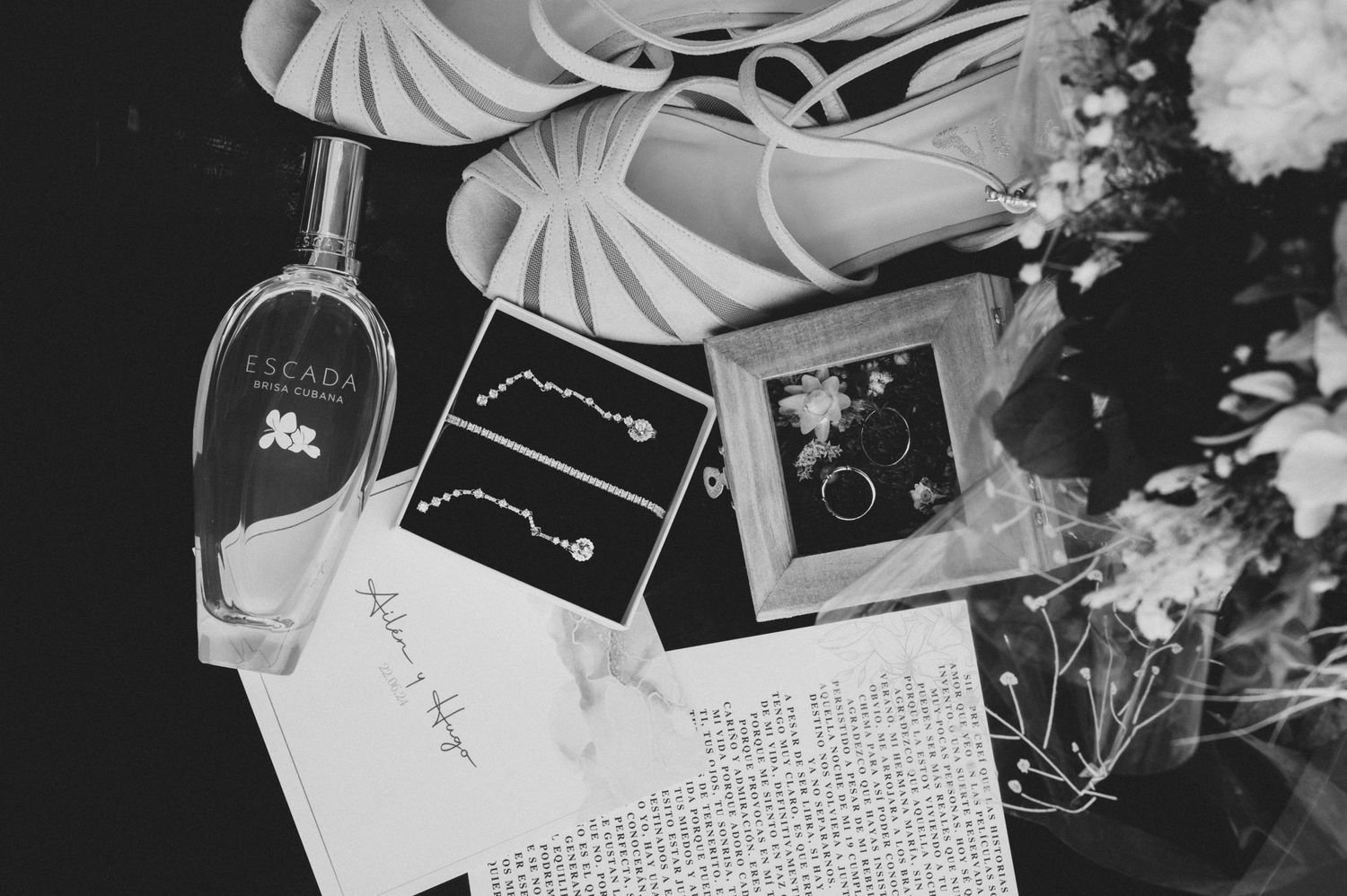 Black and white photograph of scattered photographs and handwritten notes on a flat surface.