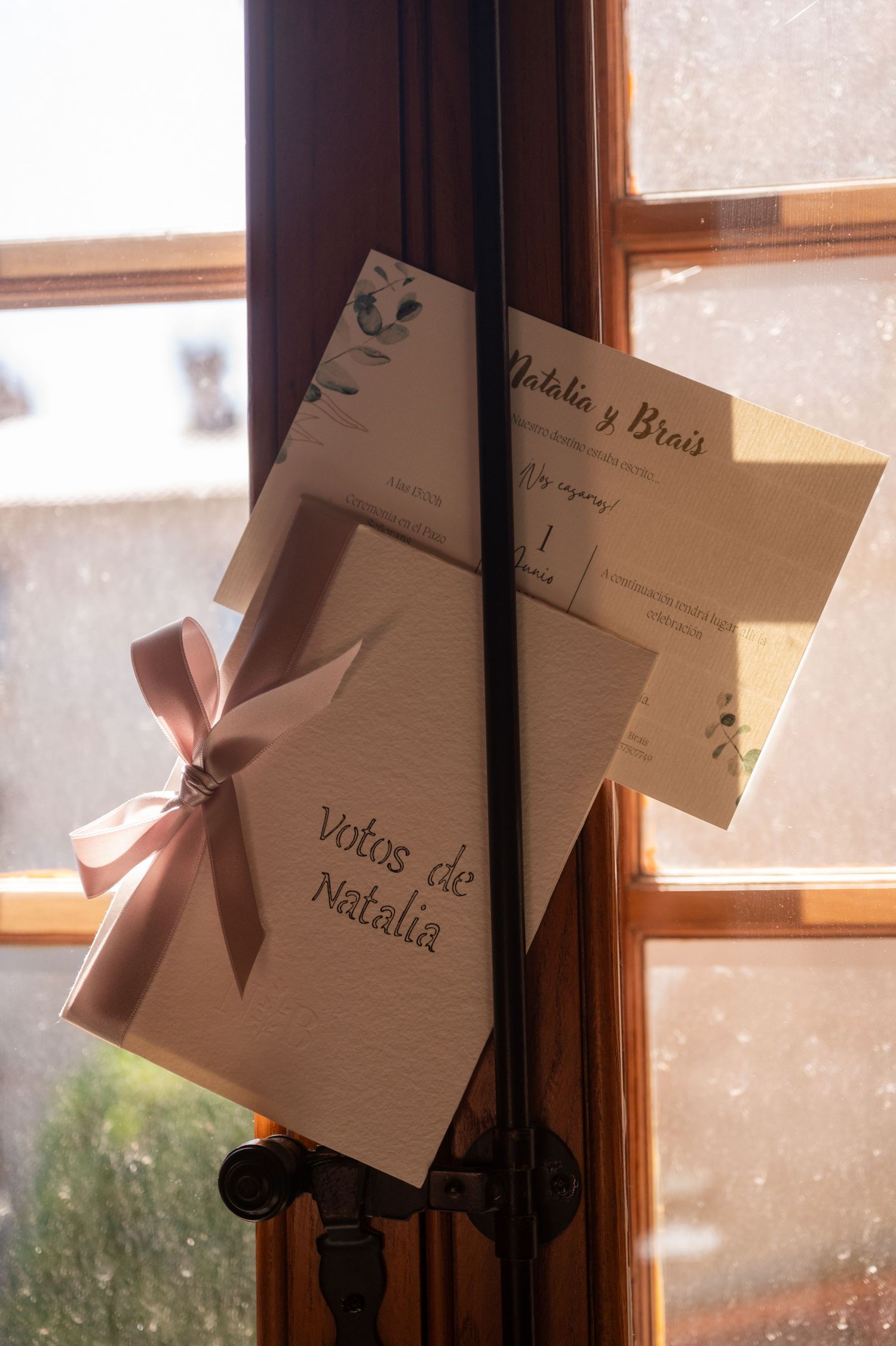 A series of papers or notes being held up against a window with sunlight streaming through creating a backlit effect.