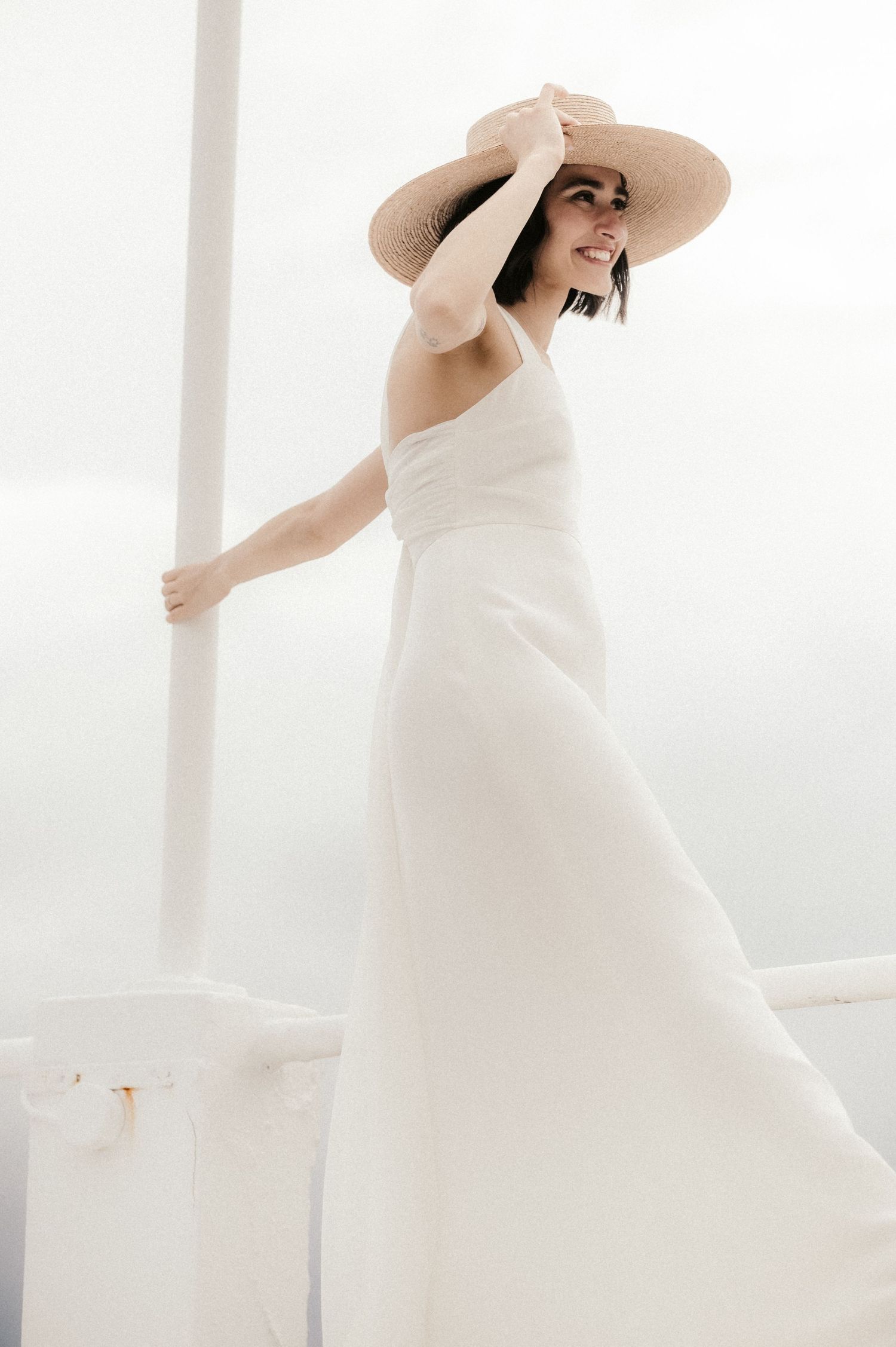A series of ethereal bridal portraits in a flowing white wedding gown and wide-brimmed hat against a bright window.
