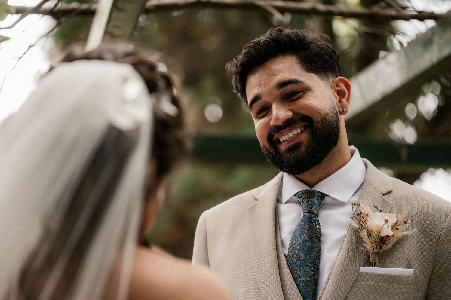 Joyful moments shared between wedding guests at an outdoor celebration under trees.