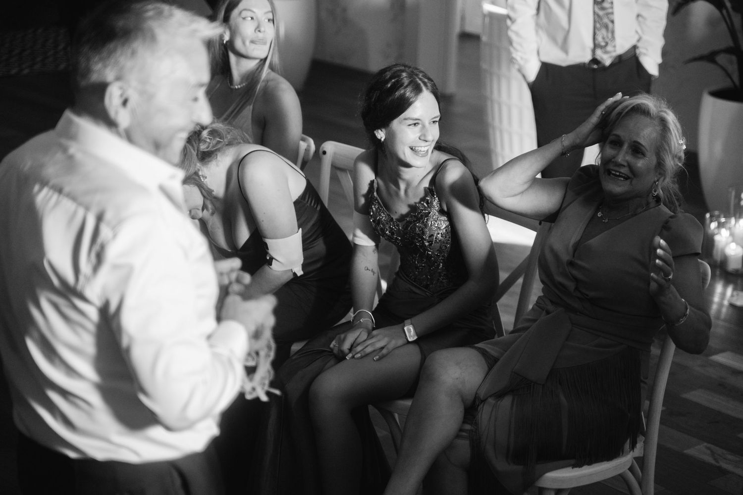 Wedding guests enjoying themselves on a dance floor in black and white photography.