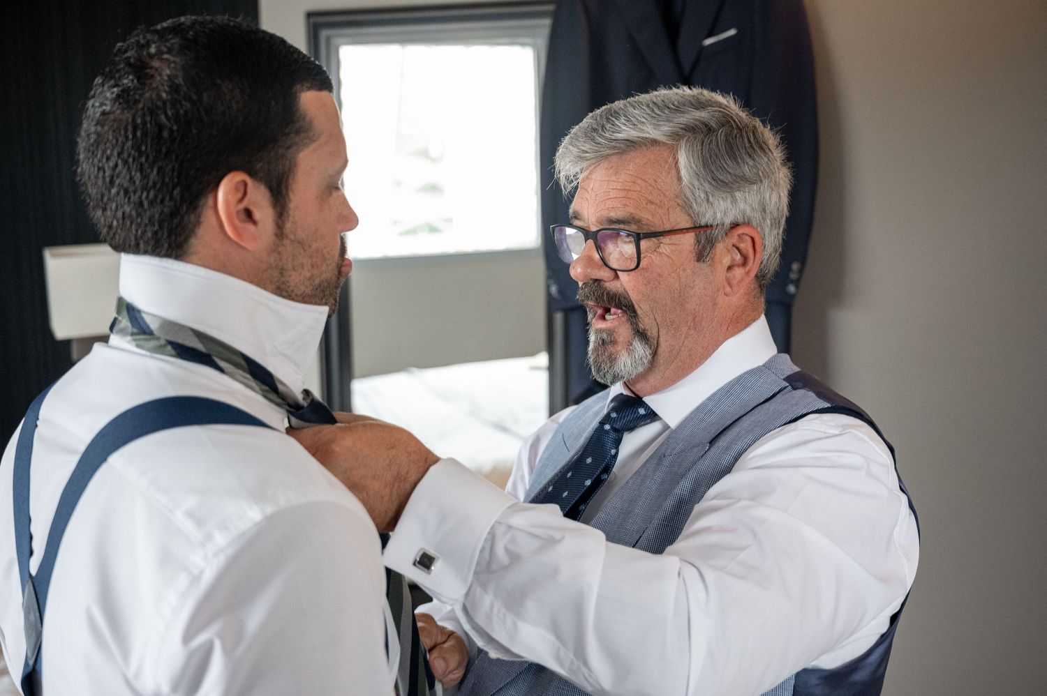 Two medical professionals in white coats review patient information together at a hospital workstation.