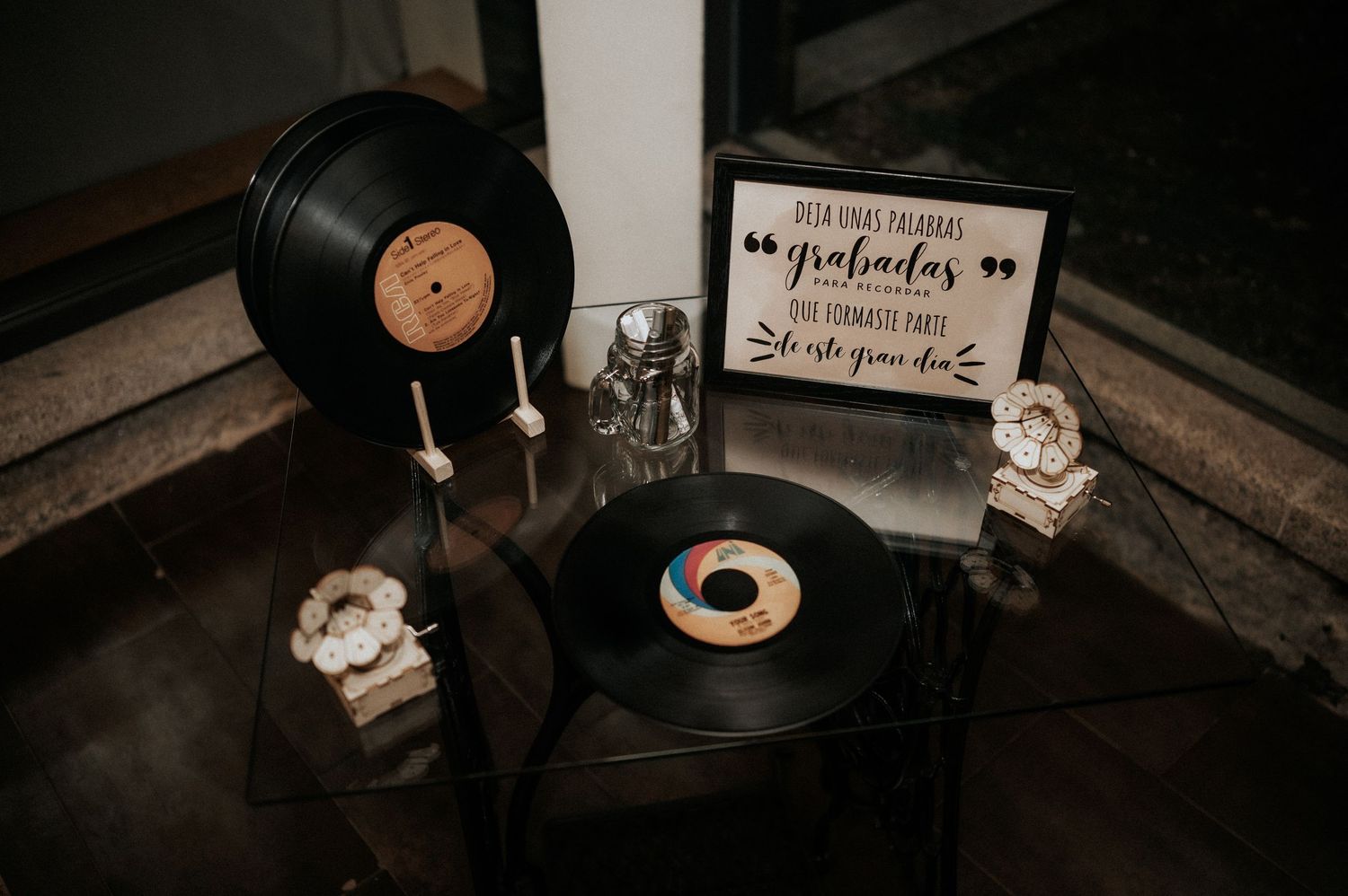 Vintage vinyl records and decorative signage displayed with rustic watches in a moody, dark setting.