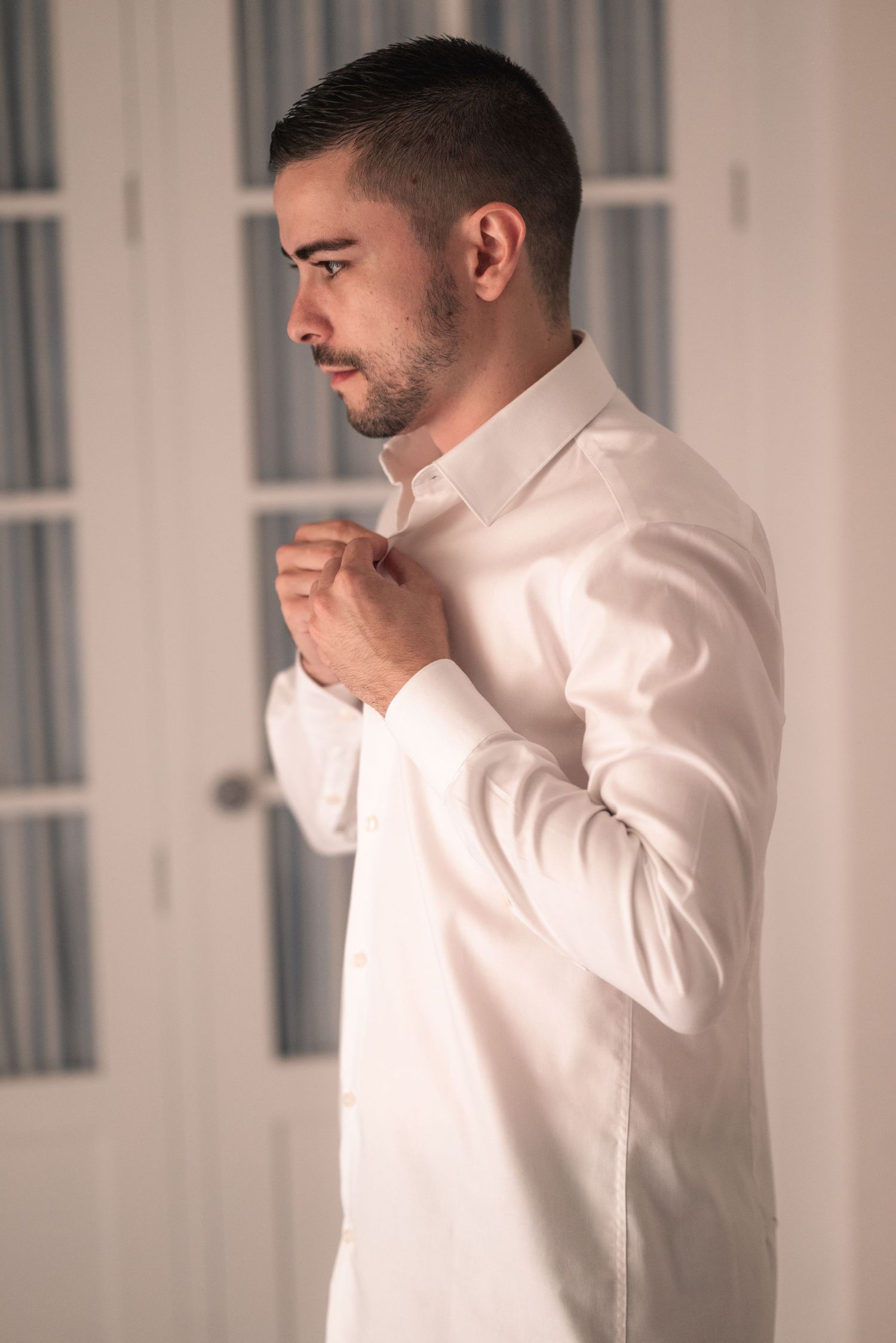 Person in white button-up shirt thoughtfully touching chin in sequence of contemplative poses against light background.