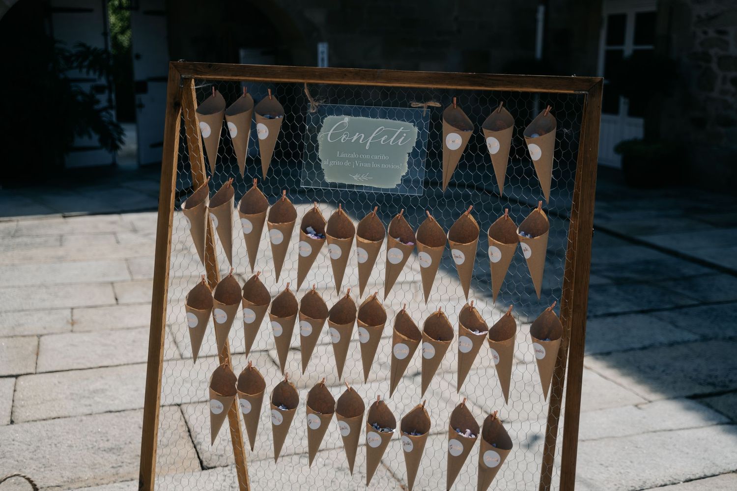 Rustic wooden frame with hanging paper decorations creating a geometric pattern.