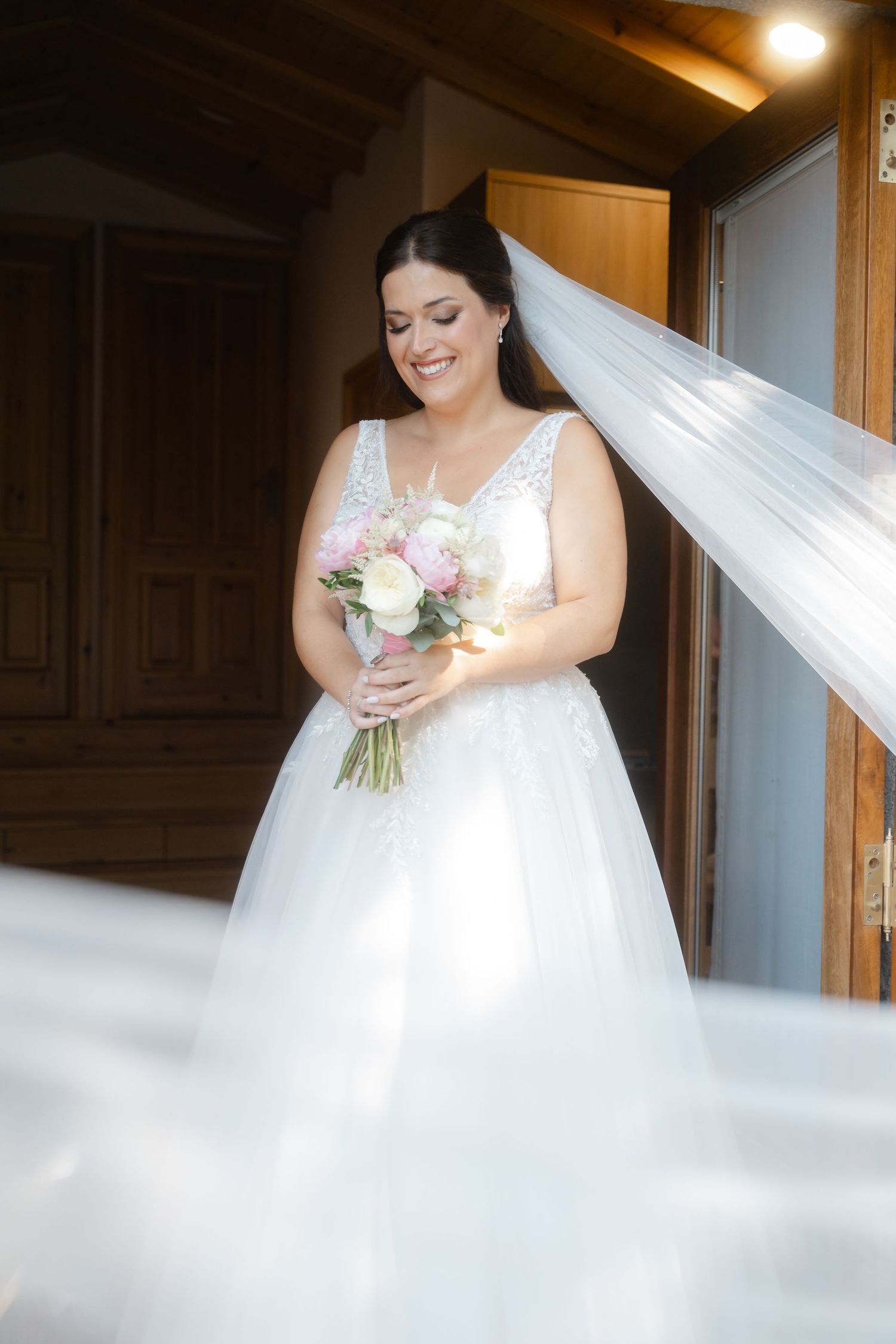 A sequence showing a person in an elegant white wedding gown holding a pink and white floral bouquet.