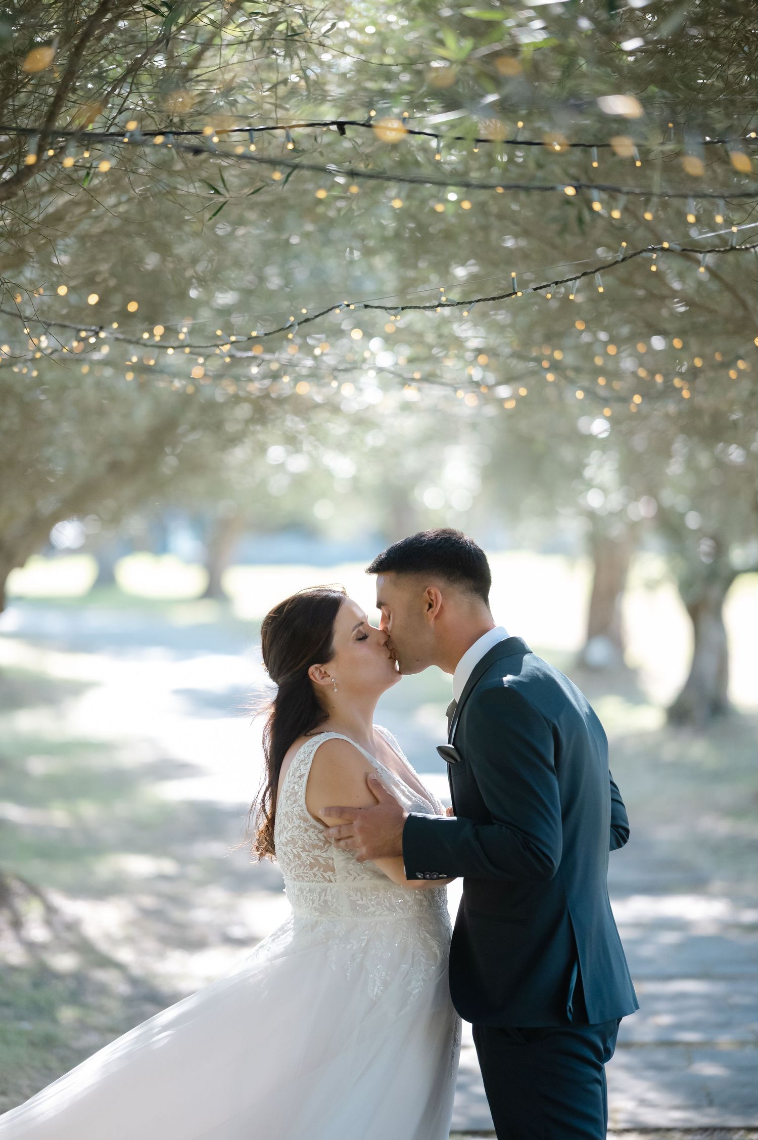 A series of romantic wedding photos capturing intimate moments between a couple under sunlit trees.