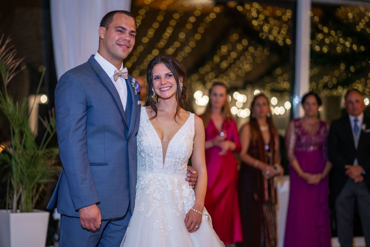 Wedding celebration with guests in formal attire and magenta bridesmaid dresses.