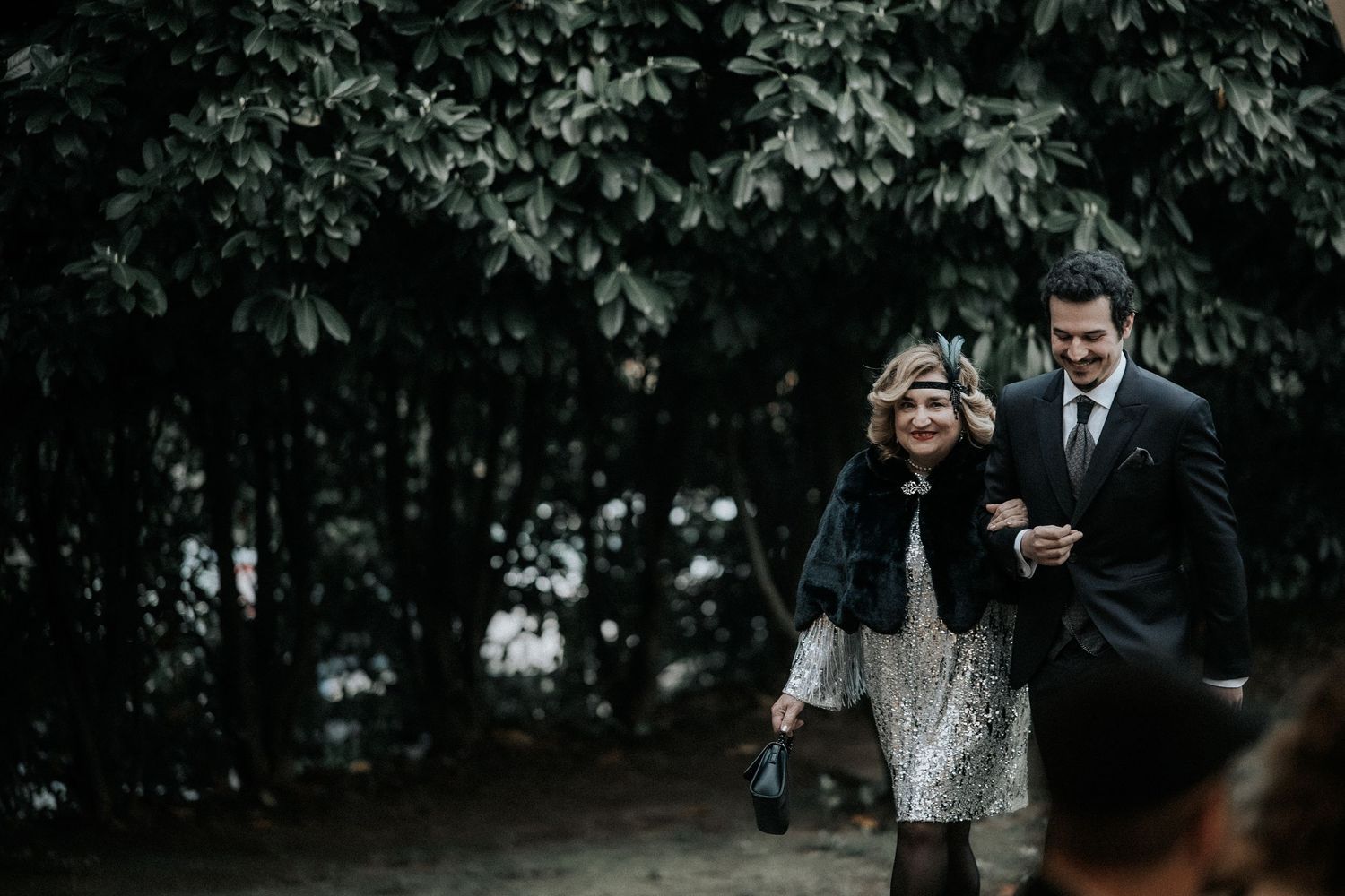 A couple walks together through a lush wooded area on a romantic outdoor photoshoot.