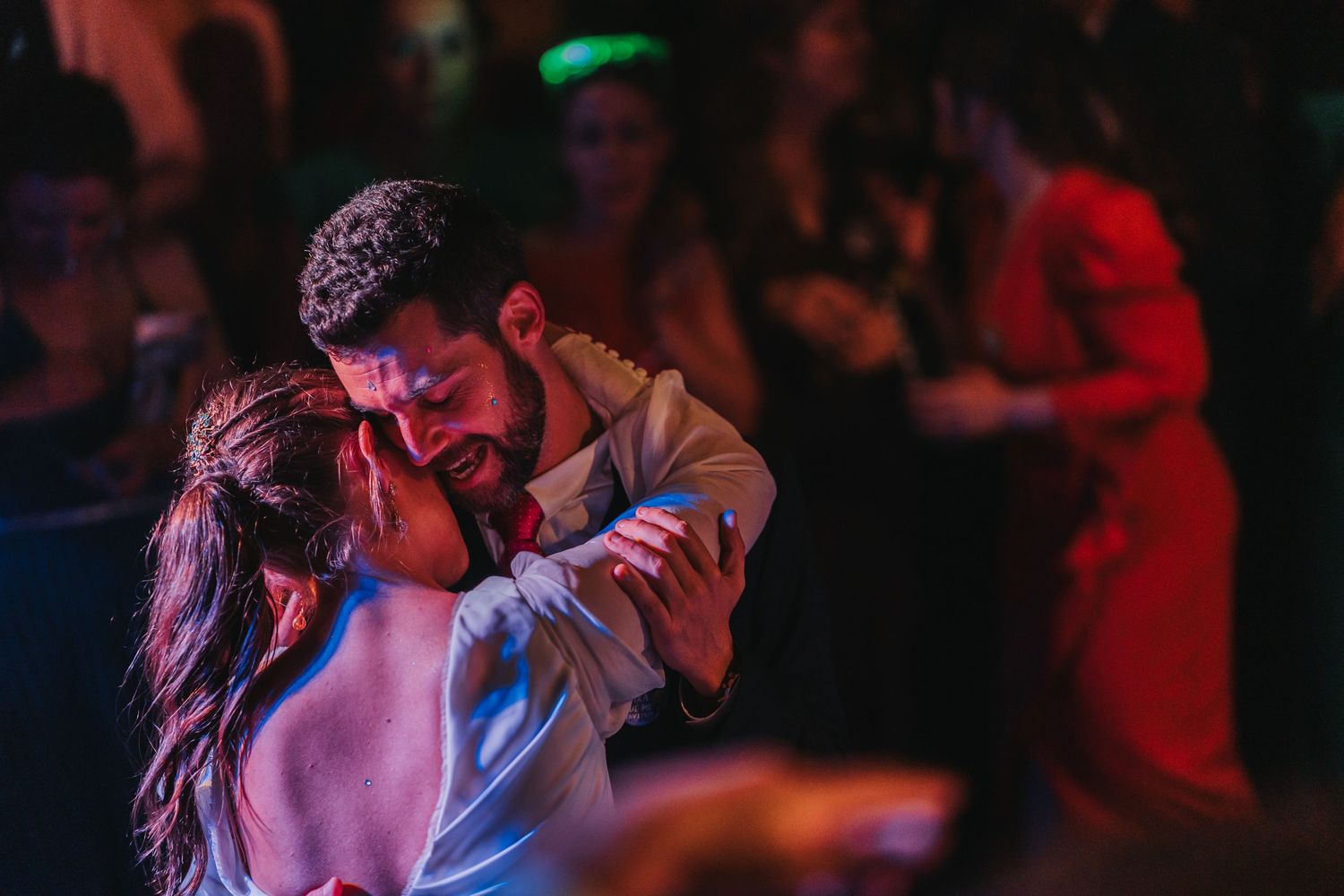 A couple performs a passionate dance move under dramatic lighting at a dance event.
