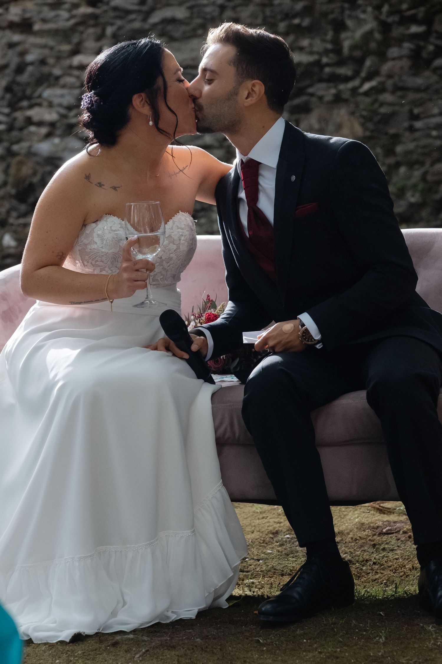 A romantic wedding moment captured in a series of photos showing a couple sharing a kiss on a stone wall.