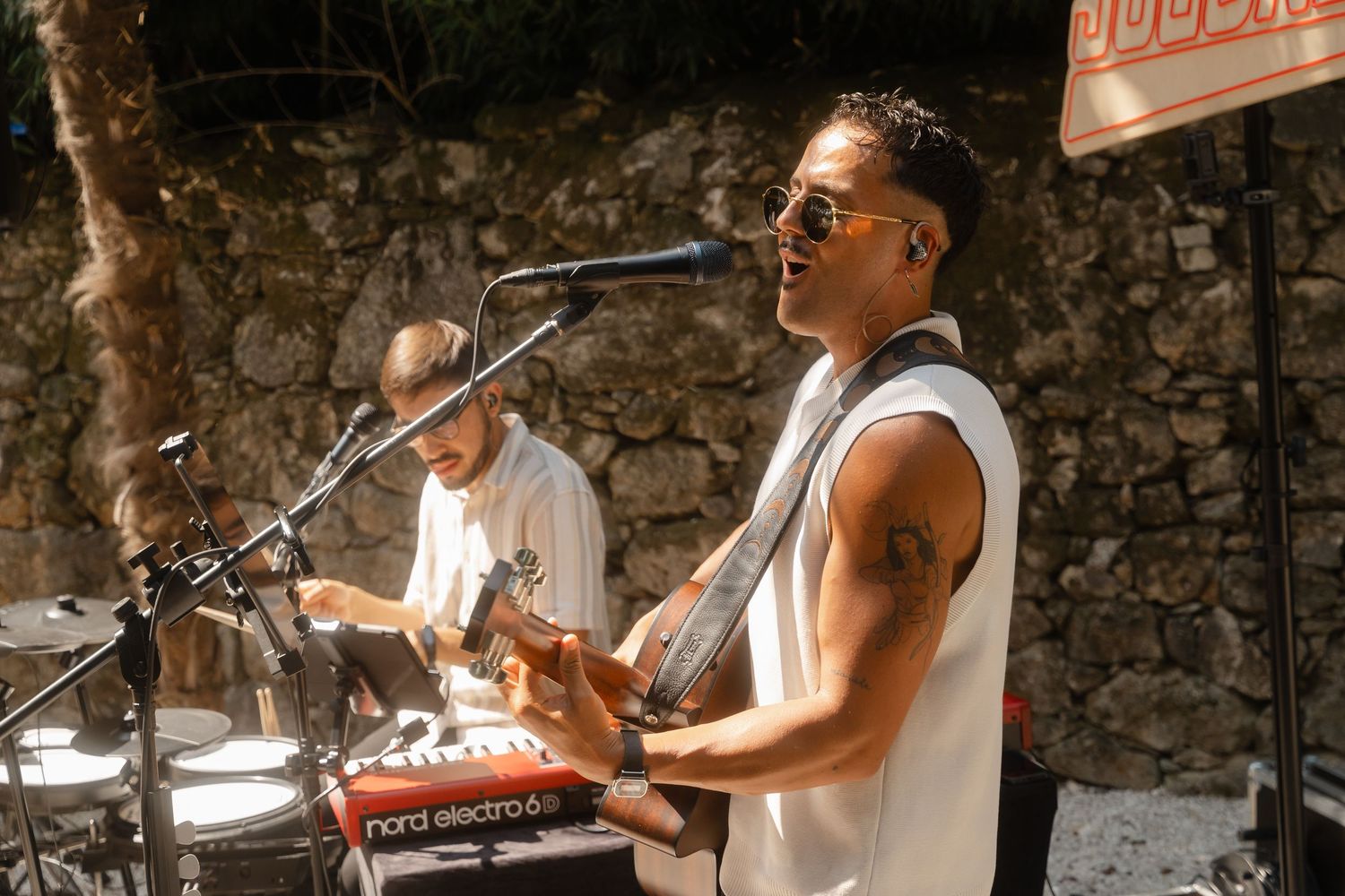 Musicians performing at a rustic stone venue with instruments and microphones set up.