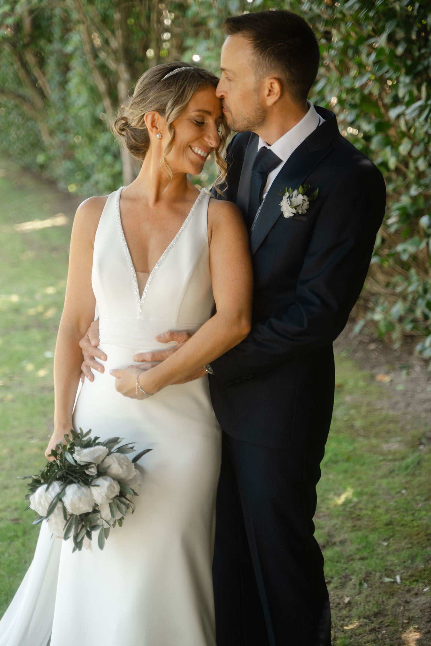 Elegant wedding portraits showing intimate moments between newlyweds against a lush garden setting.