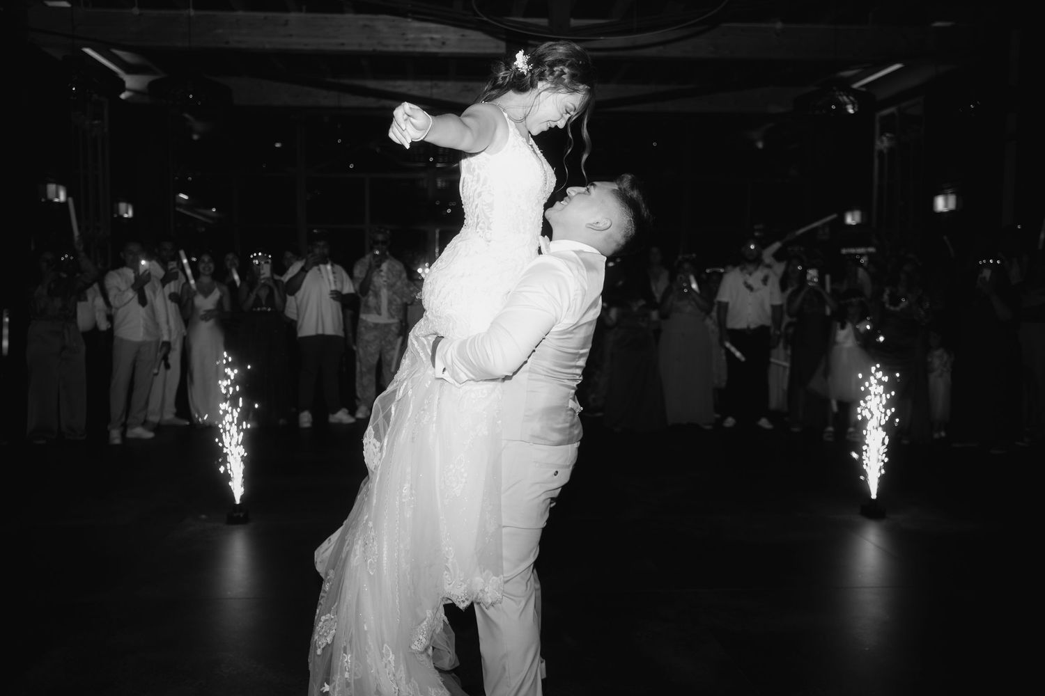 Silhouetted couple dancing together on a dark dance floor with sparkler effects in the background.