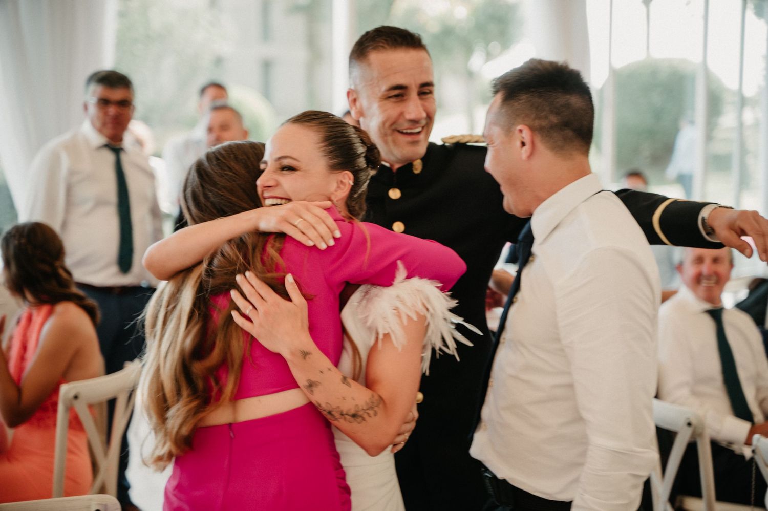 Wedding guests share emotional embraces and joyful moments during a reception celebration.