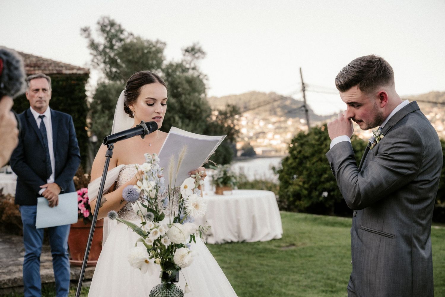 A wedding couple shares intimate moments during their outdoor celebration in a scenic mountain setting.