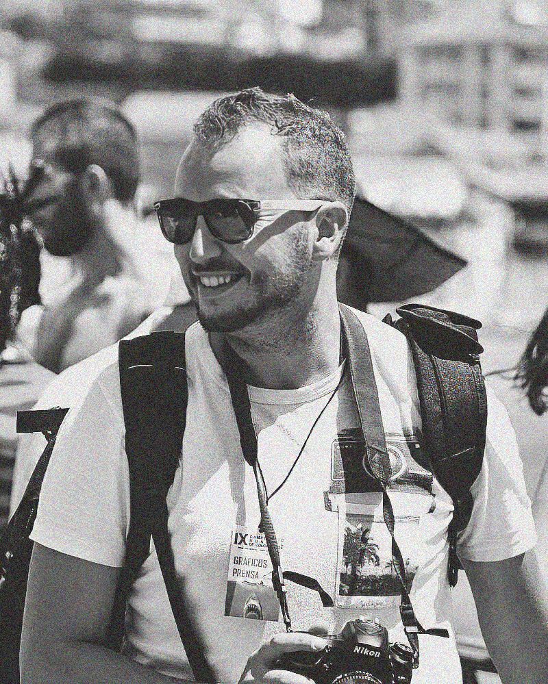 Black and white photo showing people wearing sunglasses and headsets at an outdoor event.