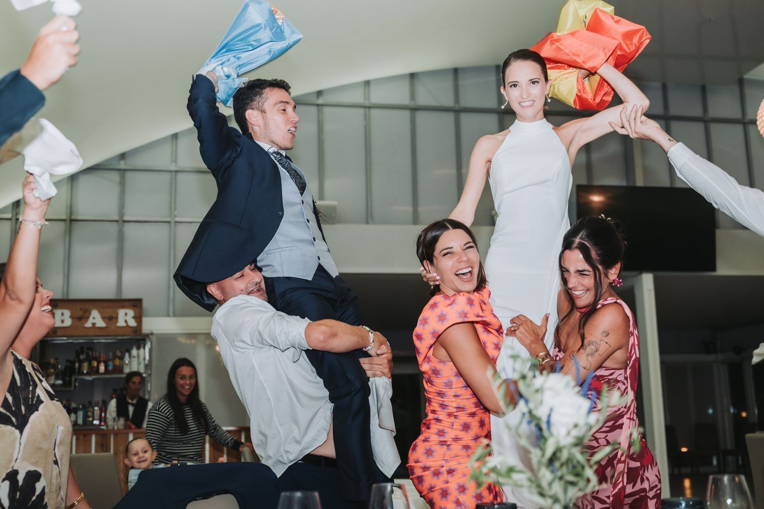 Wedding party members are hoisted up during an energetic dance celebration.