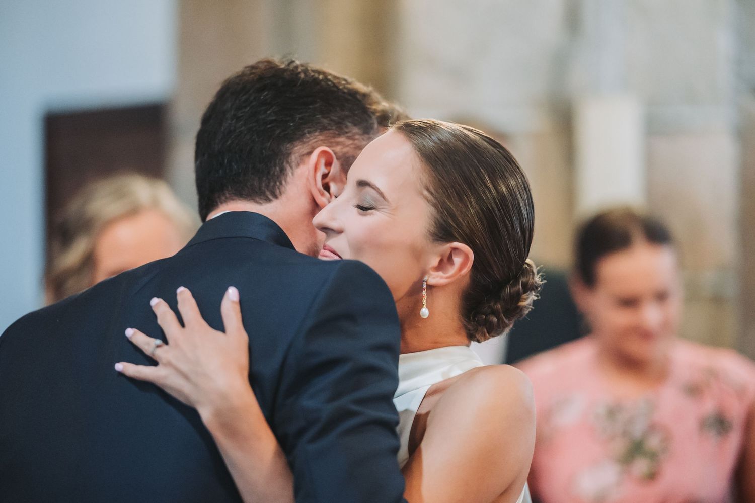 A couple shares their first dance at a wedding reception surrounded by guests.