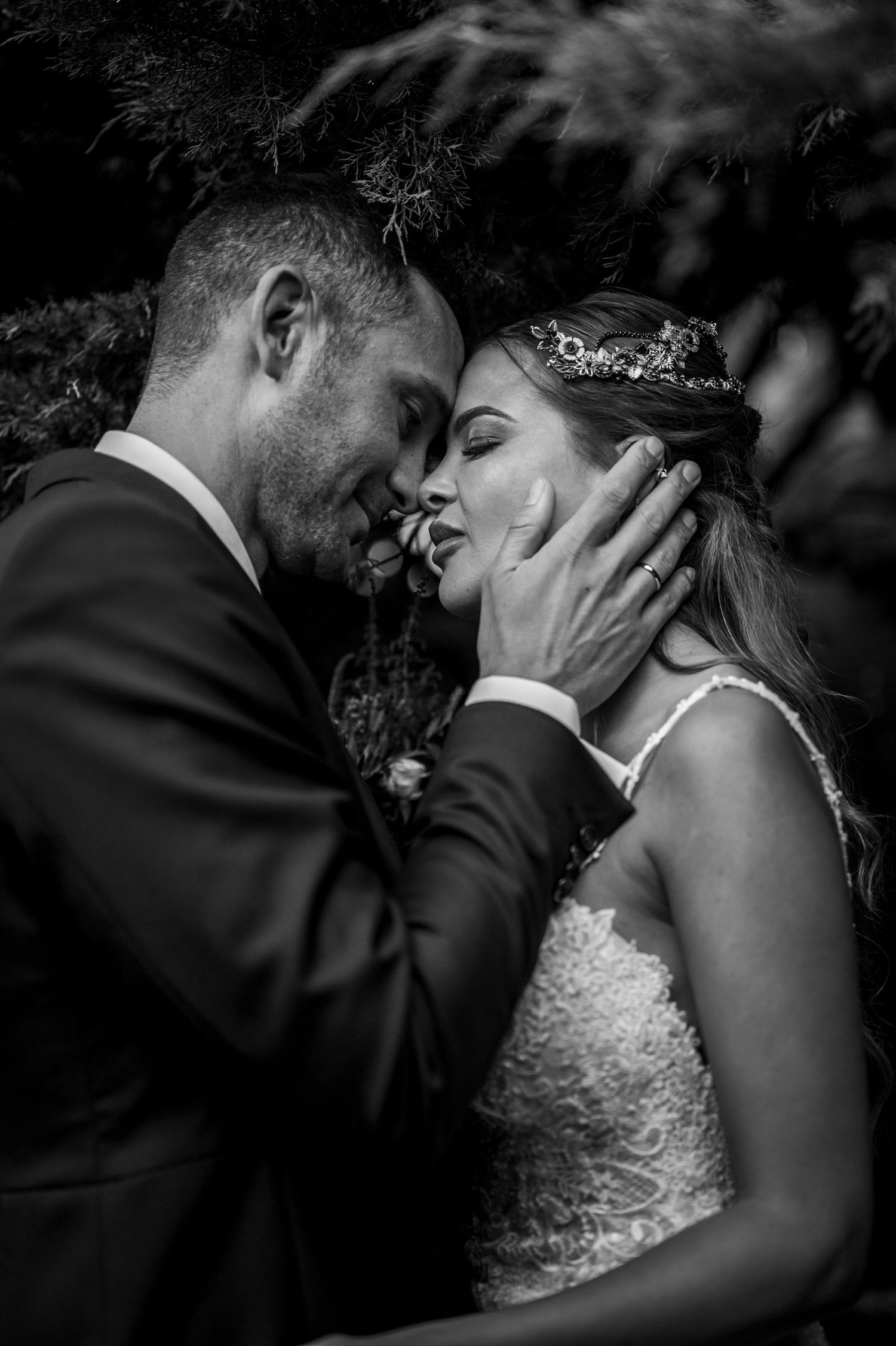 Black and white romantic wedding photos showing intimate moments between newlyweds in formal attire.